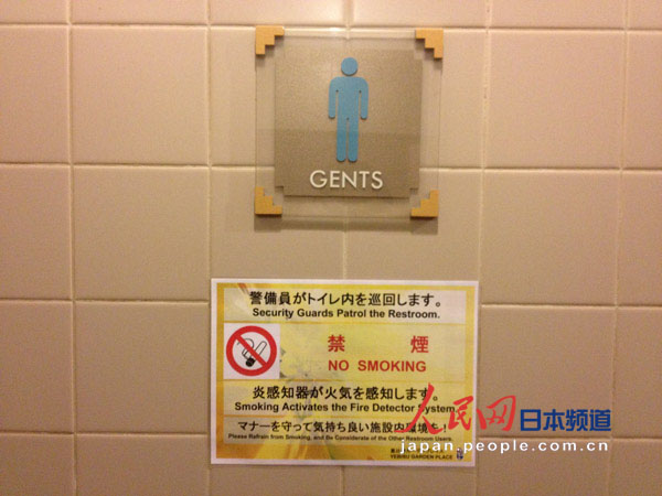 一座商务楼内的公厕。标示牌上写着“厕所内有警察巡视”，“遵守礼仪，确保厕所环境”。