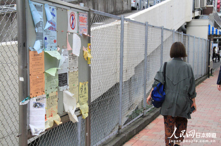 16日，车站外被台风吹乱的广告招贴。