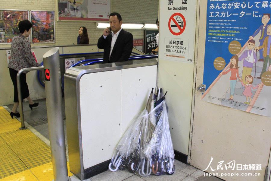 16日，工作人员将因被台风损坏而遗弃的雨伞收集到车站一角。