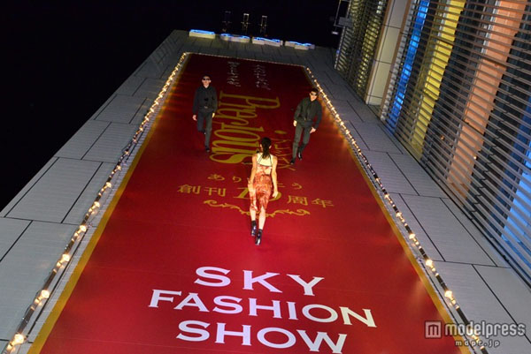 日本举行高空时装秀 模特身吊威亚墙面走T台