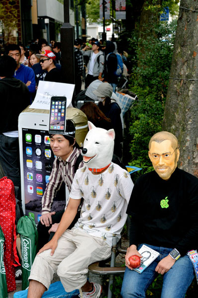 东京涩谷，19日上午，奇装异服的果粉排队等候iPhone6发售。（朝日新闻）