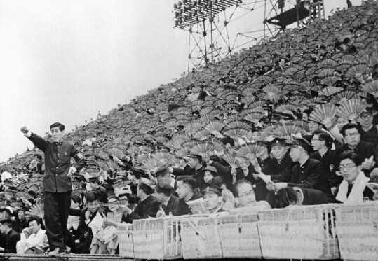 1954年6月1日，東京明治公園應慶大學和早稻田大學的棒球比賽上，觀眾們手持扇子為各自的球隊吶喊助威。
