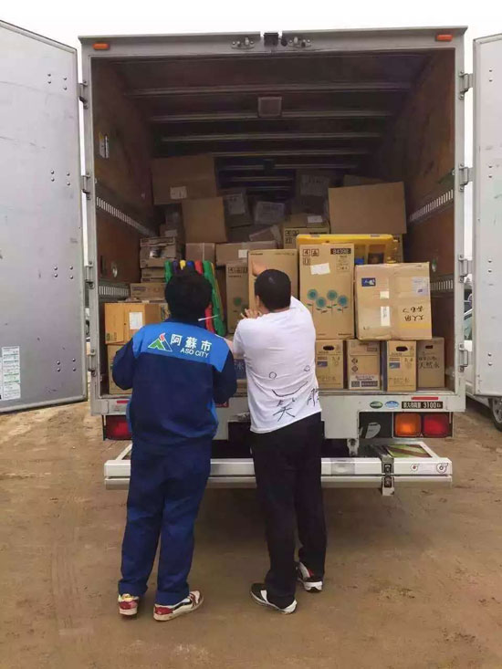 志願團成員在與熊本阿蘇市的人員一起確認運送來的救災物資。