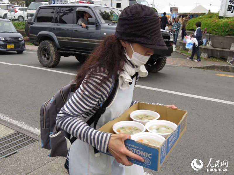 4月23日，益城町內一位端著領取的熱湯匆匆返回避難地點