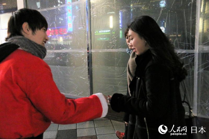 “聖誕老人“在街頭為行人分發糖果等禮物