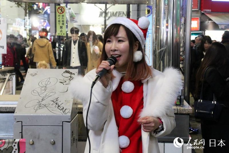 裝扮成聖誕老人的女孩在街頭唱歌