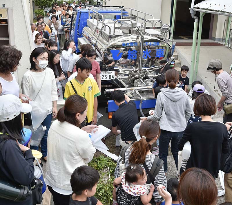6月18日，在日本大阪，一輛供水車向受災居民提供飲用水。新華社/美聯