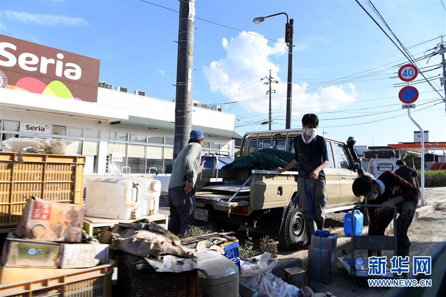 7月10日，在日本岡山縣倉敷市真備町一家超市前，工作人員在整理浸過水的貨物。日本西部地區連降特大暴雨，引發30多年來最嚴重水災。據日本媒體匯總，截至7月10日上午，已有至少130人喪生，將近60人失聯。新華社記者 馬平攝