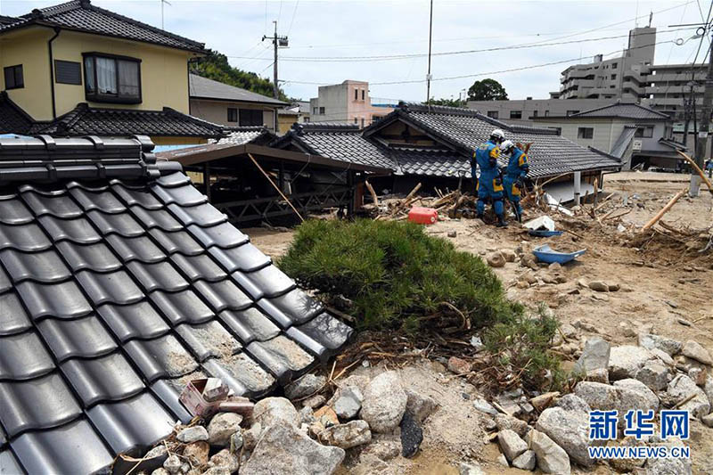 7月11日，在日本廣島吳市天應町地區，警察挖掘被泥石流淹沒的民居。持續多日的暴雨導致日本多地出現洪水及泥石流等災害。　新華社記者馬平攝