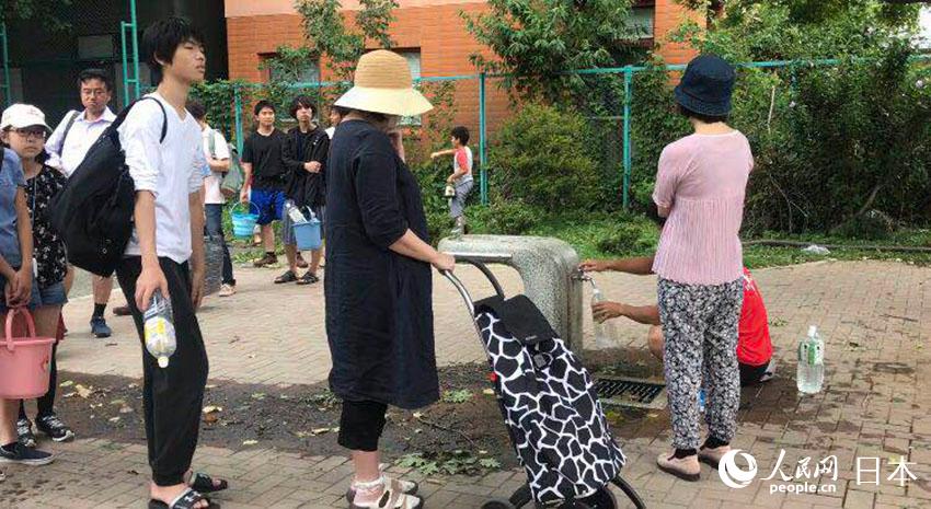 在札幌市中心，日本市民排隊拿水桶在街區花園打水。（圖片由北海道大學在讀中國留學生提供）