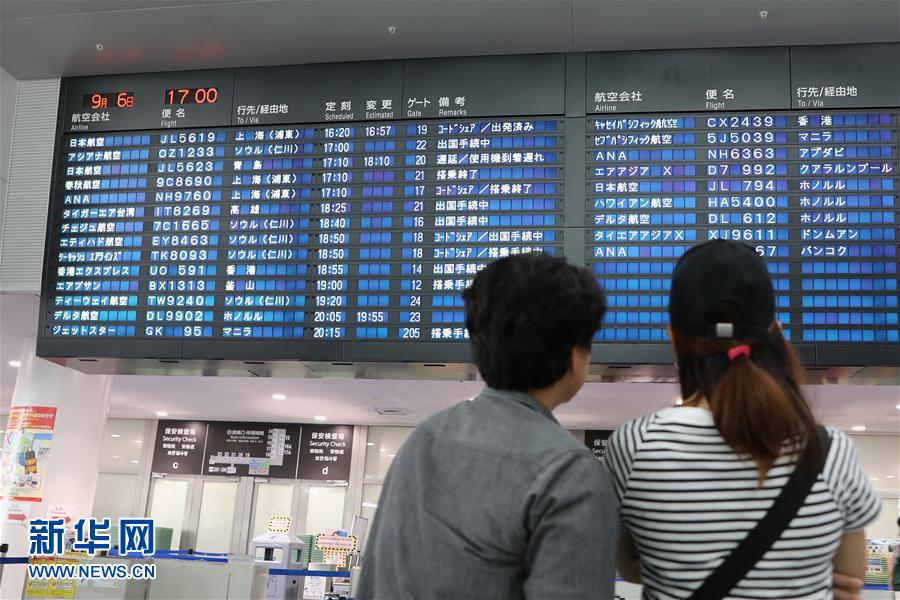 9月6日，在日本名古屋中部國際機場，兩名旅客查看國際出發航班情況。屏幕上顯示，多趟飛往上海的航班中，春秋航空的9C8690為當日增設的臨時航班。