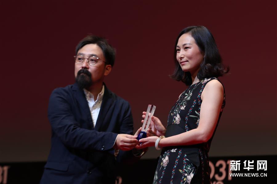 中國導演王麗娜（右）在作品《第一次的離別》獲“亞洲未來”單元最佳影片獎后上台領獎。新華社記者杜瀟逸攝