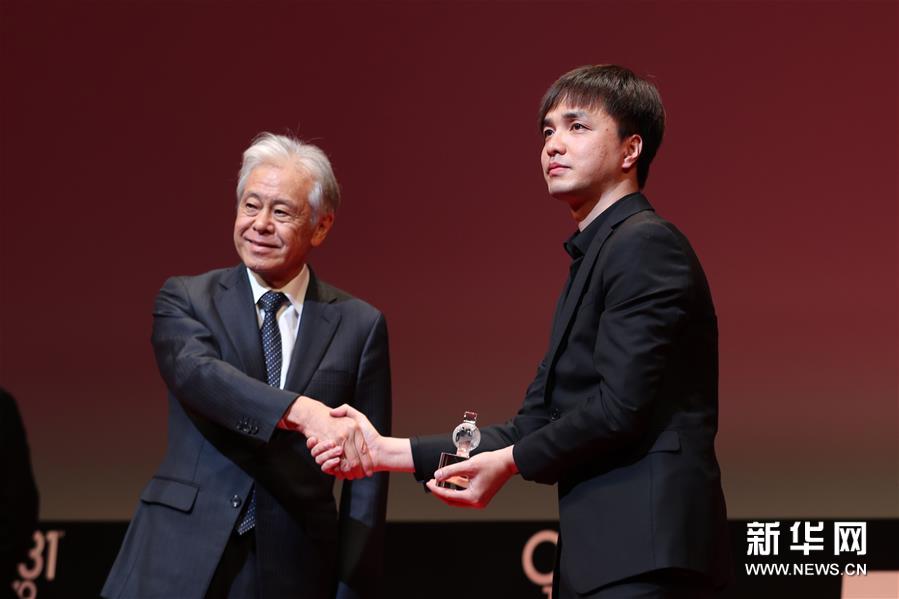 中國導演黃璜（右）在作品《武林孤兒》獲“亞洲未來”單元國際交流基金亞洲中心特別獎后上台領獎。新華社記者杜瀟逸攝