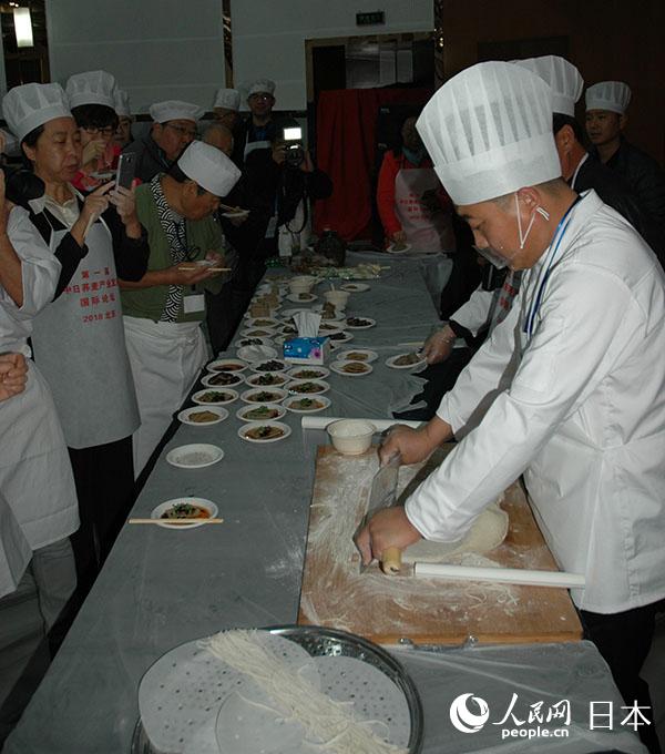 來自赤峰市敖漢旗的中方人士展示當地特色美食“敖漢撥面”的制作方法。