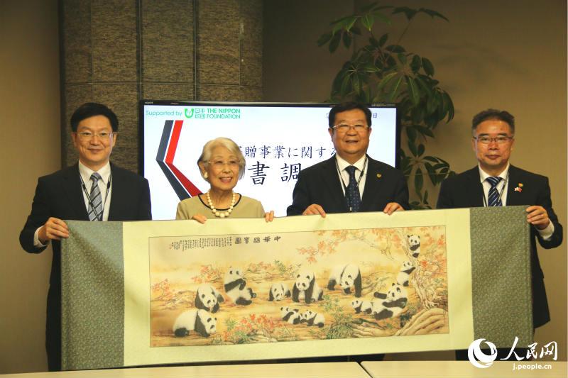 中國教育國際交流協會會長劉利民向日本科學協會會長大島美惠子贈送禮物。