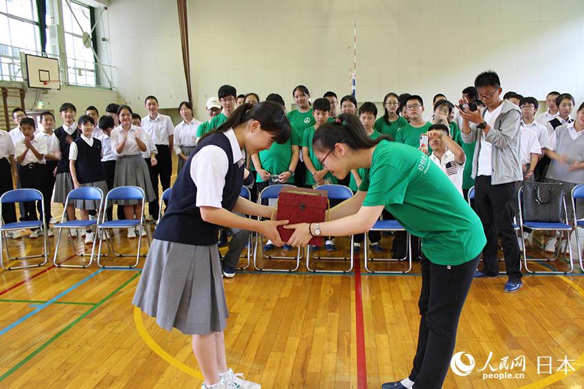 中国学生代表向日本学生代表赠送礼物。