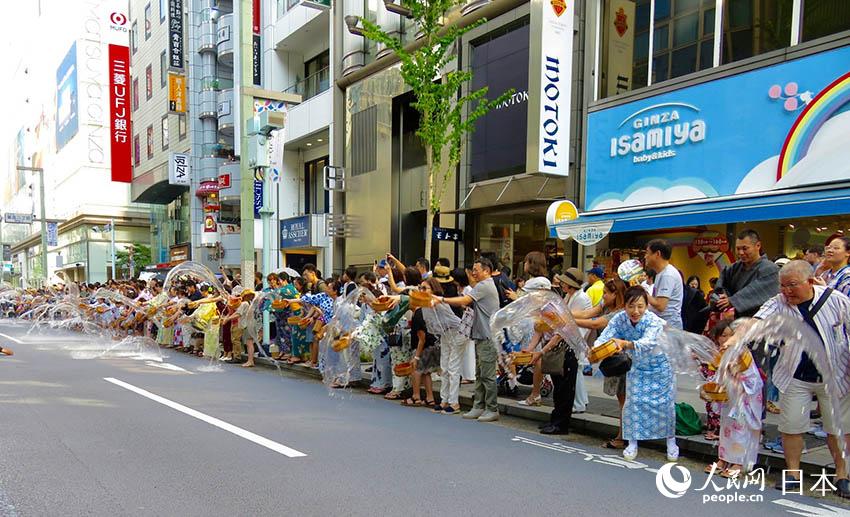 身穿浴衣的日本民众齐聚银座大街参加泼水活动。