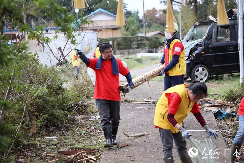 在建行東京分行總經理解陸一的帶領下，20名志願者員工在災區開展救助活動。
