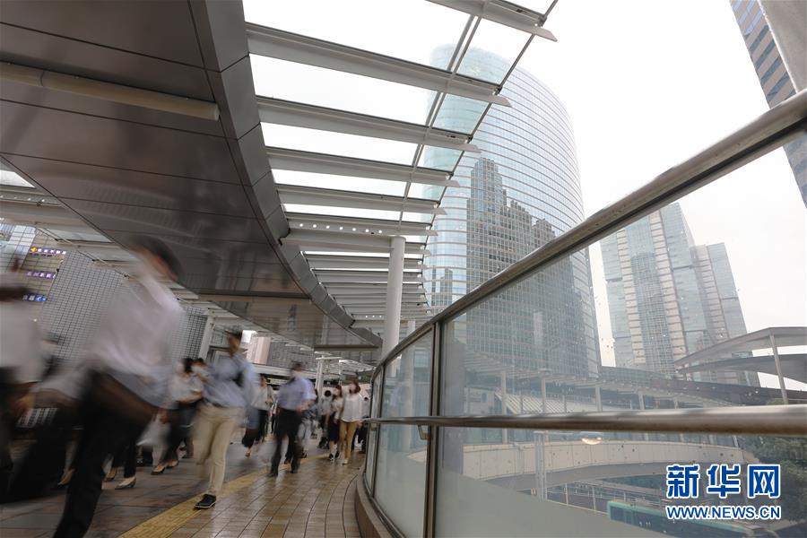 6月30日，在日本東京品川，人們下班后離開寫字樓走向車站。新華社記者 杜瀟逸 攝