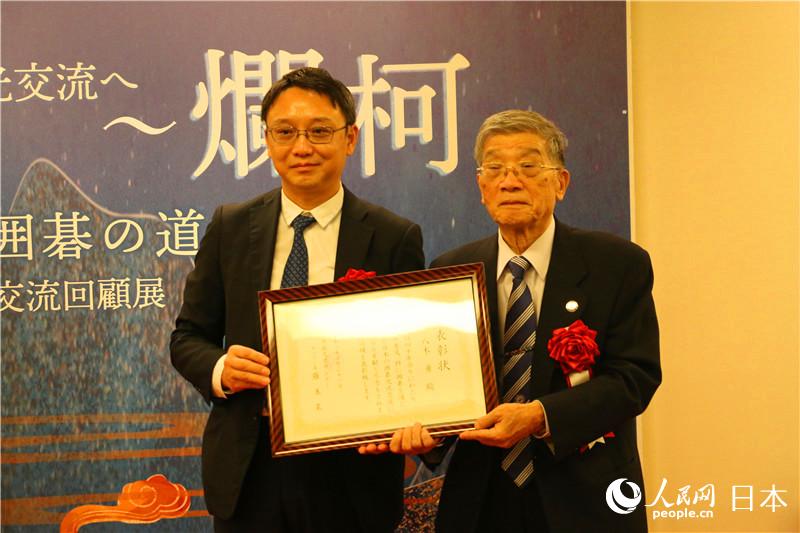 東京中國文化中心主任羅玉泉向40年來致力於中日友好交流的靜岡圍棋支部聯合會名譽會長八木勇頒發表彰証書。（李沐航 攝）