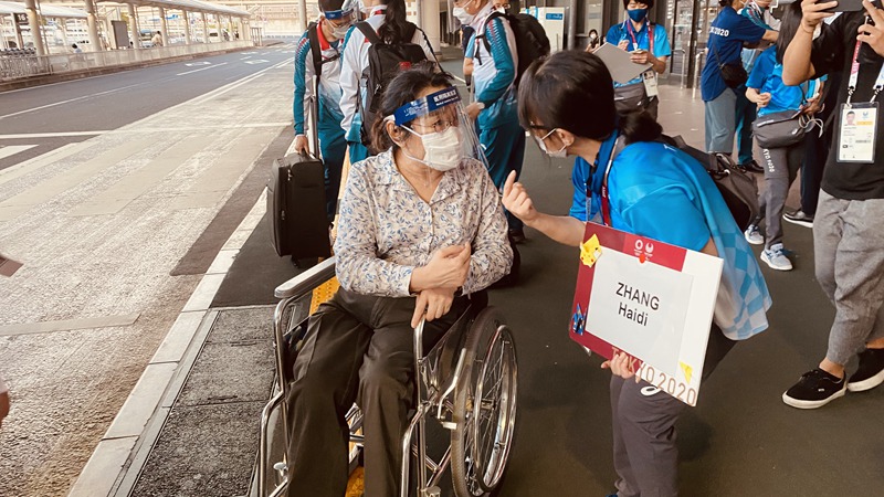 8月22日，張海迪（左一）抵達東京成田機場后與志願者交談。（圖片來源：東京成田機場工作人員供圖）