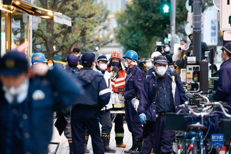 12月17日，救援人員聚集在日本大阪發生火災的樓房附近。