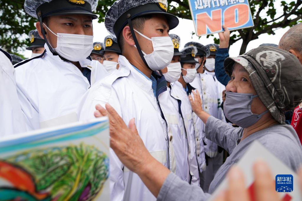 5月15日，在日本沖繩，警察在沖繩回歸日本本土50周年紀念儀式現場外阻攔抗議者。新華社記者 張笑宇 攝