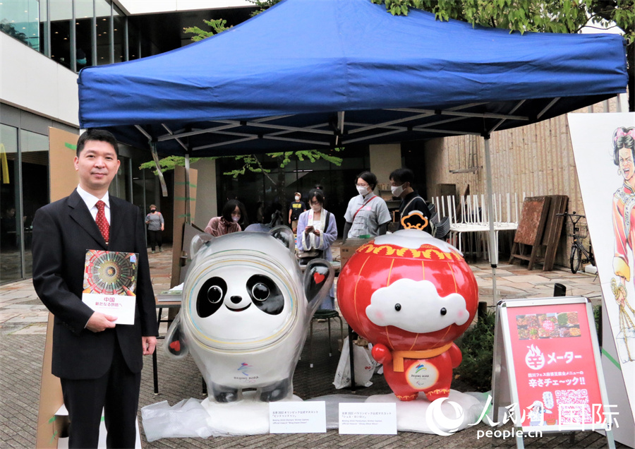 5月14日，中国驻东京旅游办事处主任欧阳安在冬奥吉祥物“冰墩墩”、“雪容融”前宣传中国旅游。（人民网吴颖 摄）