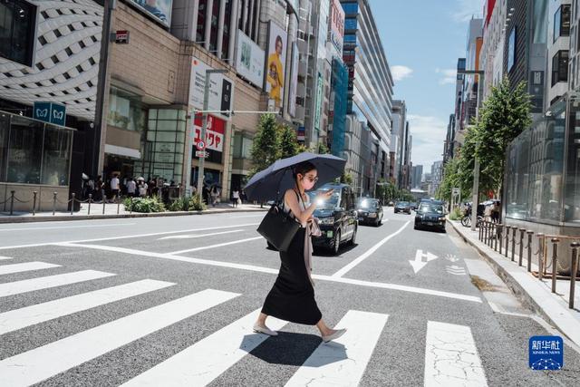 日本迎來高溫天氣，行人打著遮陽傘走過東京銀座街頭