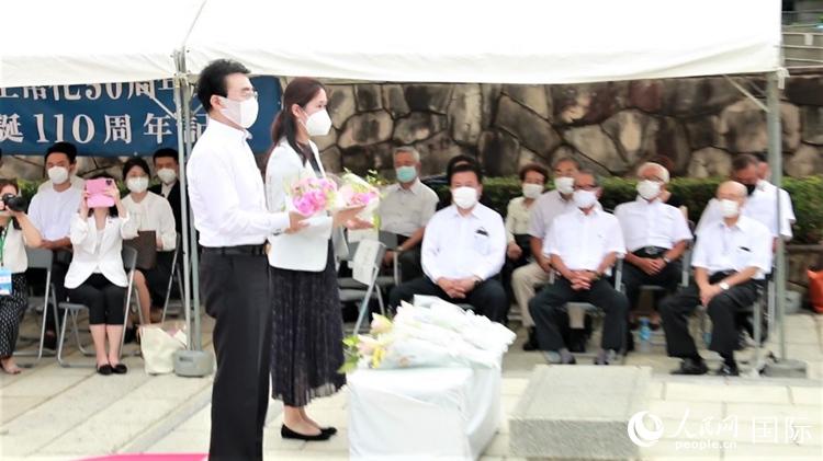 7月17日，中國駐日本大使館參贊聶佳和在日中國企業協會會長王家馴（左）在活動上向聶耳雕像敬獻鮮花。人民網 吳穎攝