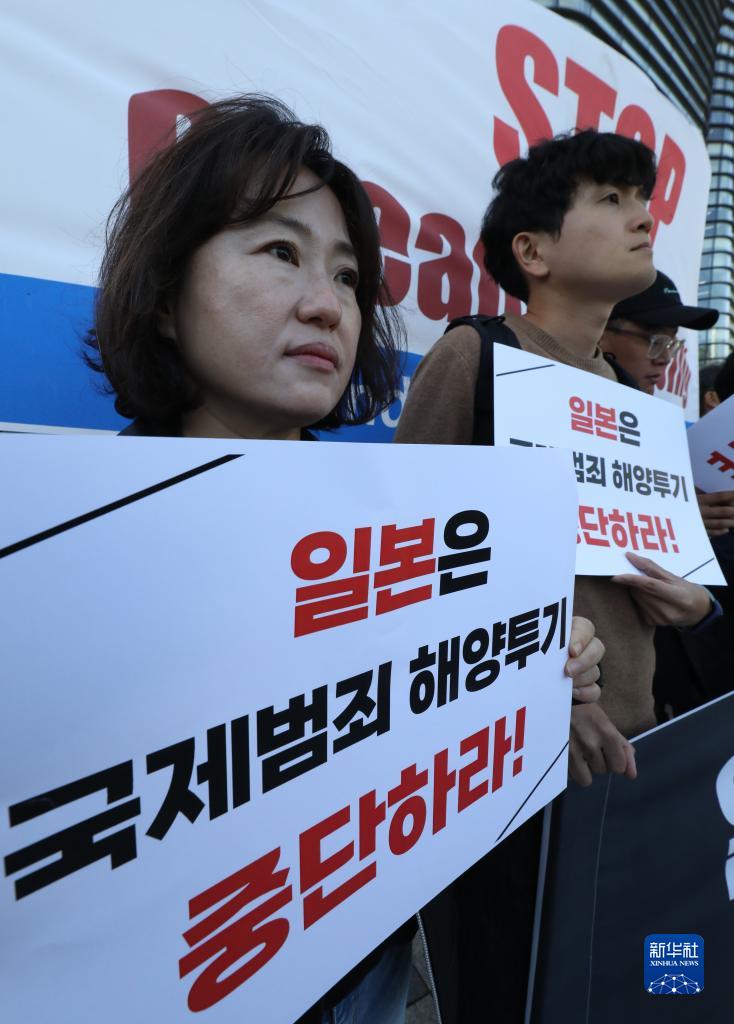 10月5日，人们手持标语在韩国首尔的日本驻韩国大使馆前谴责日本政府启动第二轮核污染水排海。新华社/纽西斯通讯社