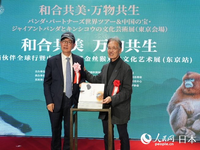 薛康（左）與土居利光（右）為《中國雙寶：享譽世界的大熊貓和金絲猴》攝影畫冊發布揭幕。人民網 許可攝