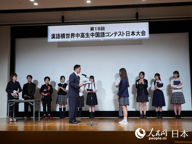 中国驻日本大使馆公使衔参赞杜柯伟（前左）为一等奖获得者上田优奈颁奖。人民网 许可摄
