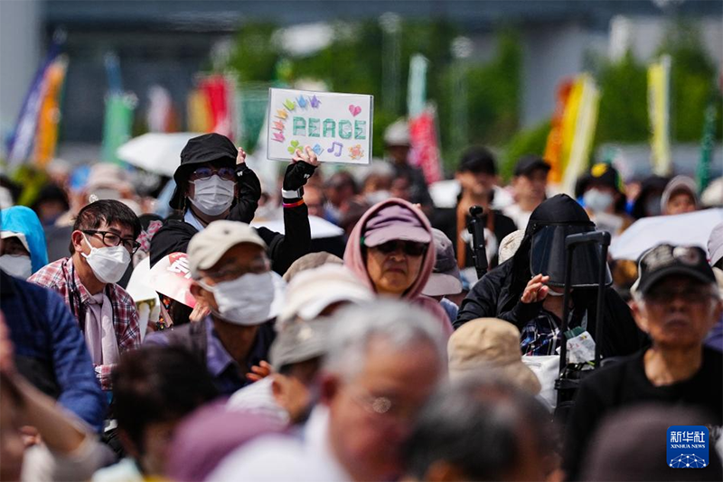 5月3日，在日本东京有明防灾公园，民众手持标语参加集会。新华社记者 贾浩成 摄