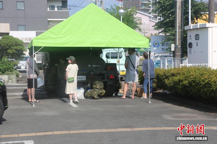 当地时间8月1日，日本熊本县八代市居民在自卫队设置的临时供水处取水。中新社记者 朱晨曦 摄