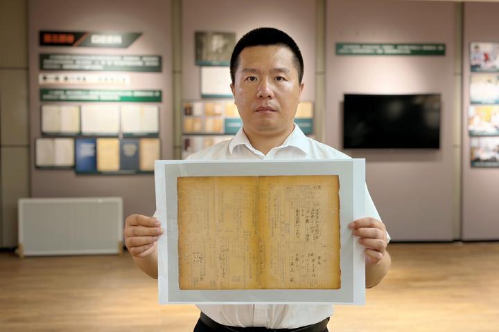 侵华日军第七三一部队罪证陈列馆研究人员金士成展示731部队海拉尔支队《身上申告书》影印件。（受访者供图）