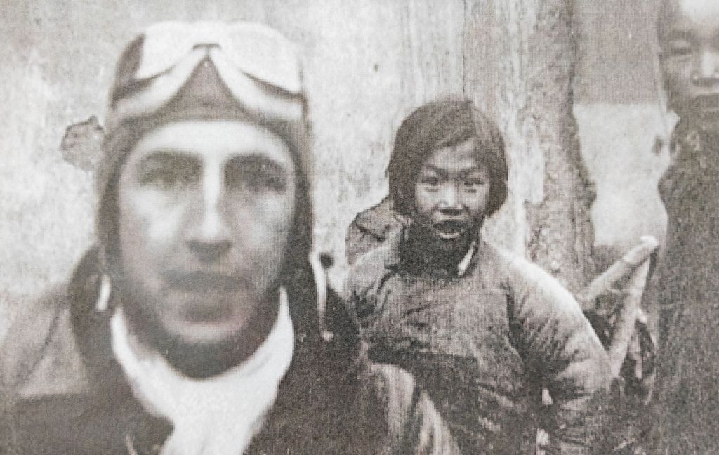 這是1942年4月，在江西上饒市廣豐區，9歲的小女孩官冬香（中）站在美國飛行員身后。