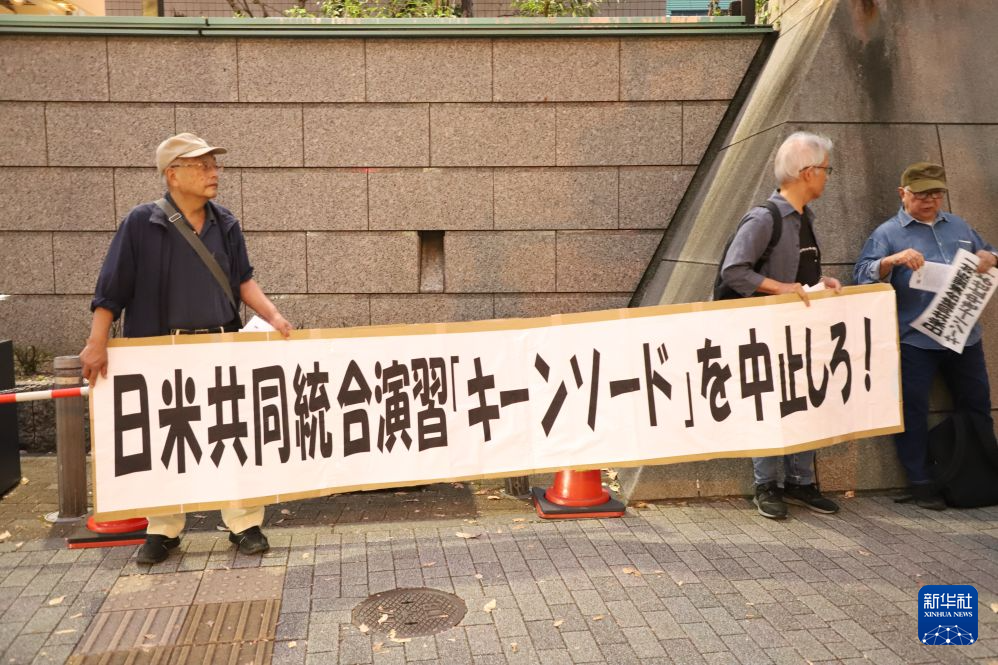 10月20日,在日本东京,抗议者手持横幅抗议。新华社记者 李子越 摄