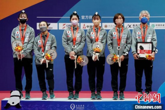 日本女团头戴“大熊猫”开心领奖。　国际乒联供图