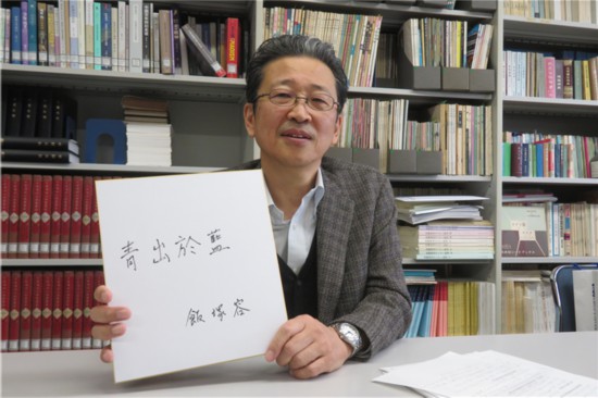 飯塚教授展示自己書寫的中國古語“青出於藍”。（視頻採訪截圖）